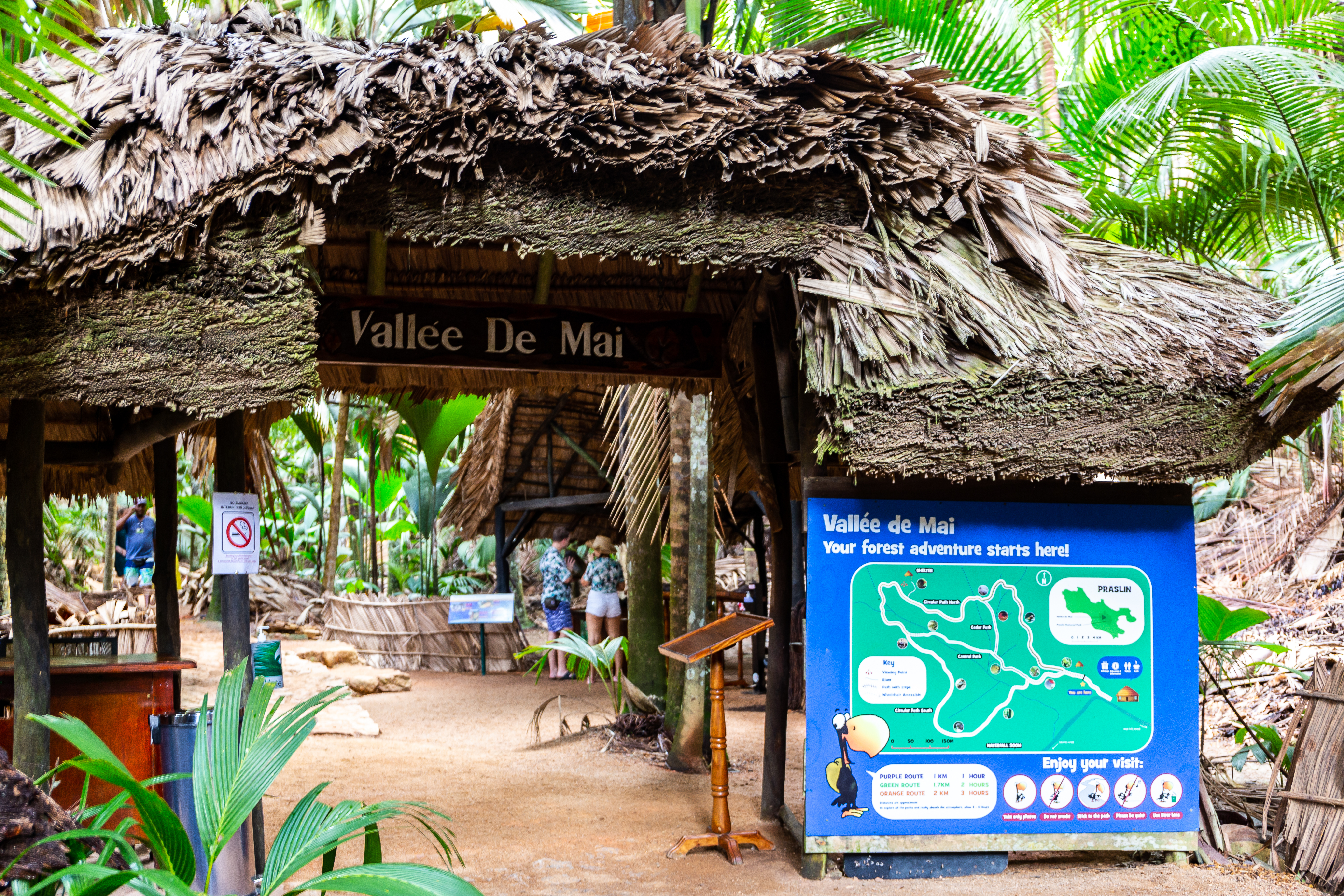 Shutterstock 1990527278 Vallee De Mai Nature Reserve Entrance Gate With Thatched Roof With Dried Palm Tree Leaves And Map Of A Reseve.
