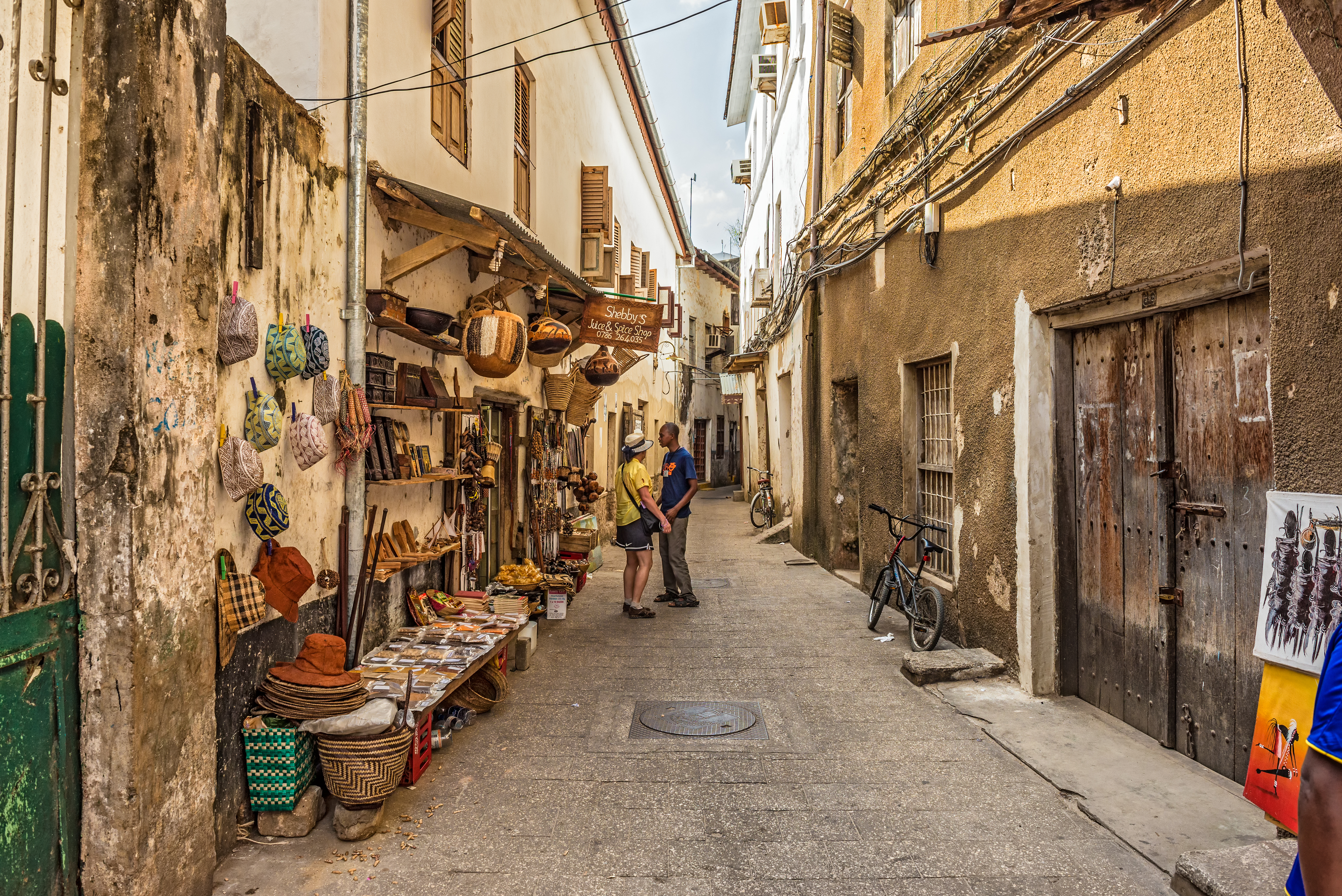 shutterstock_241056031 STONE TOWN, ZANZIBAR - OCTOBER 24, 2014 Tourists on a typical narrow street in Stone Town..jpg