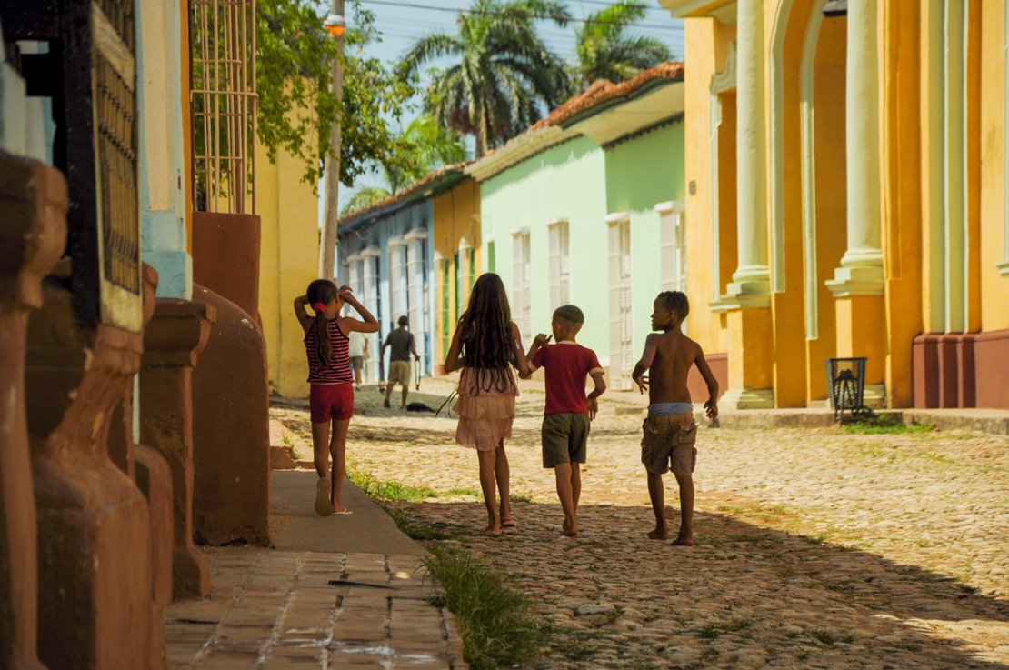 Cubanske børn går på gaden i Trinidad