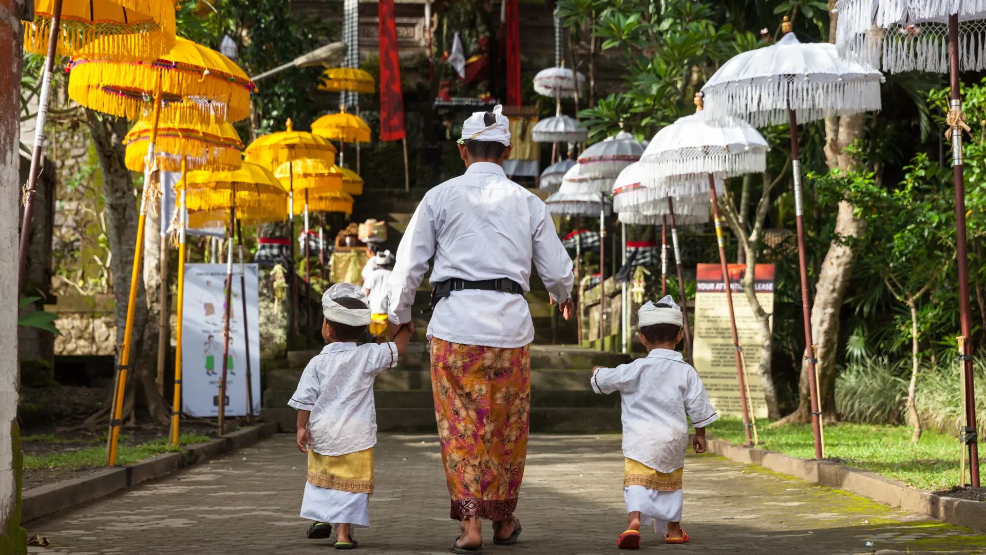 UBUD, INDONESIA - MARCH 2 Man with children walks up the stairs during the celebration before Nyepi (Balinese Day of Silence).jpg