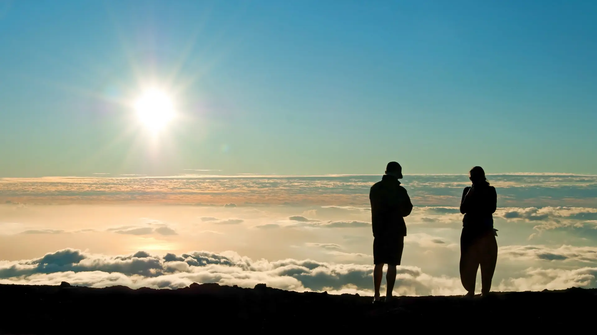 Tourist silhouette watching sunset on the top of Haleakala volcano on Maui Hawaii.jpg