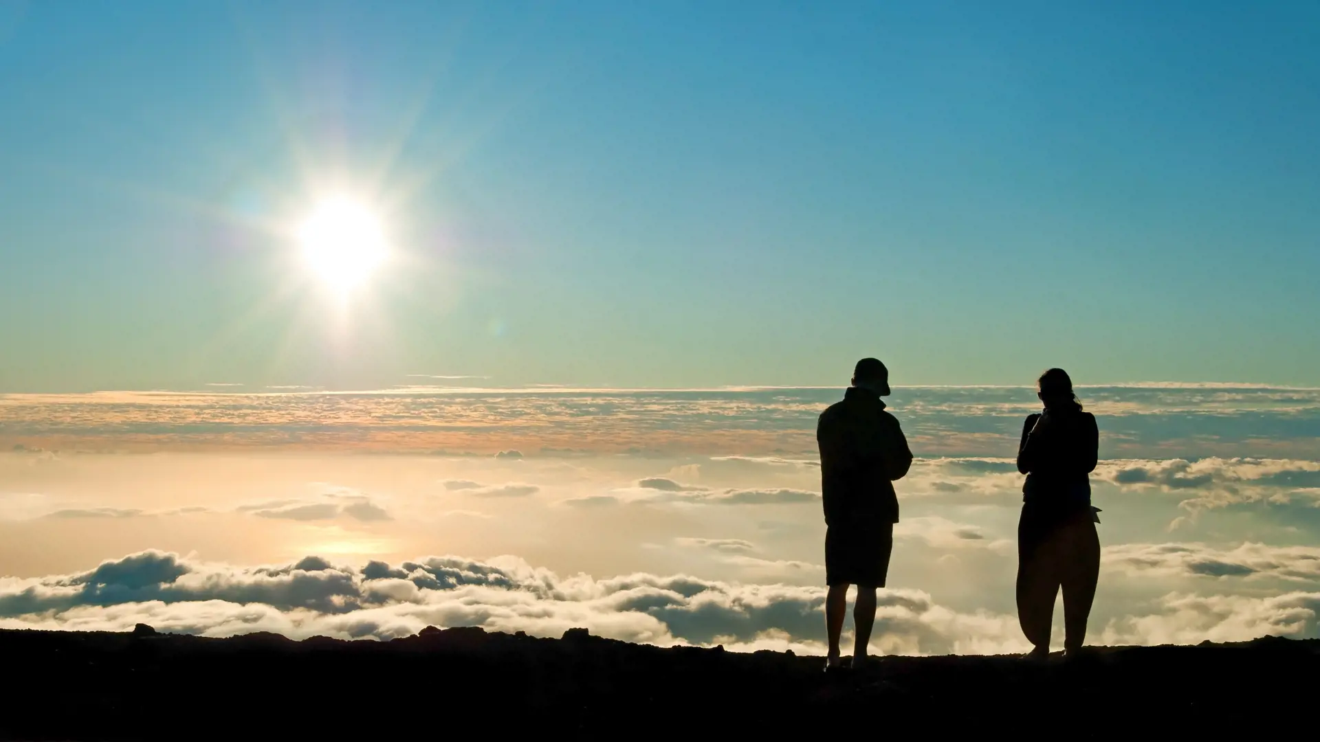 Tourist silhouette watching sunset on the top of Haleakala volcano on Maui Hawaii.jpg
