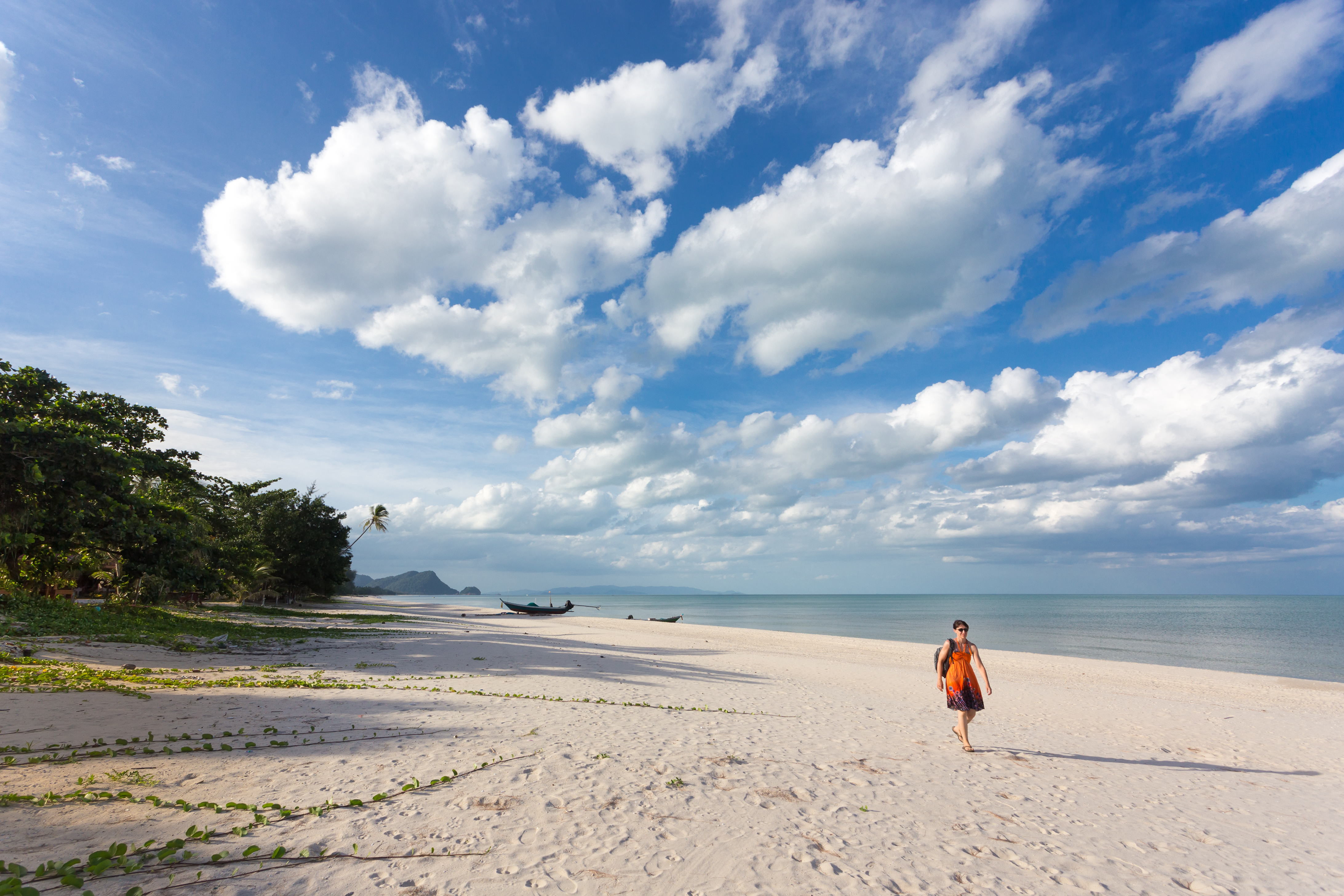 Shutterstock 153480185 (One Woman Walking On Wild Tropical Khanom Beach Under A Blue And Cloudy Sky, Thailand)