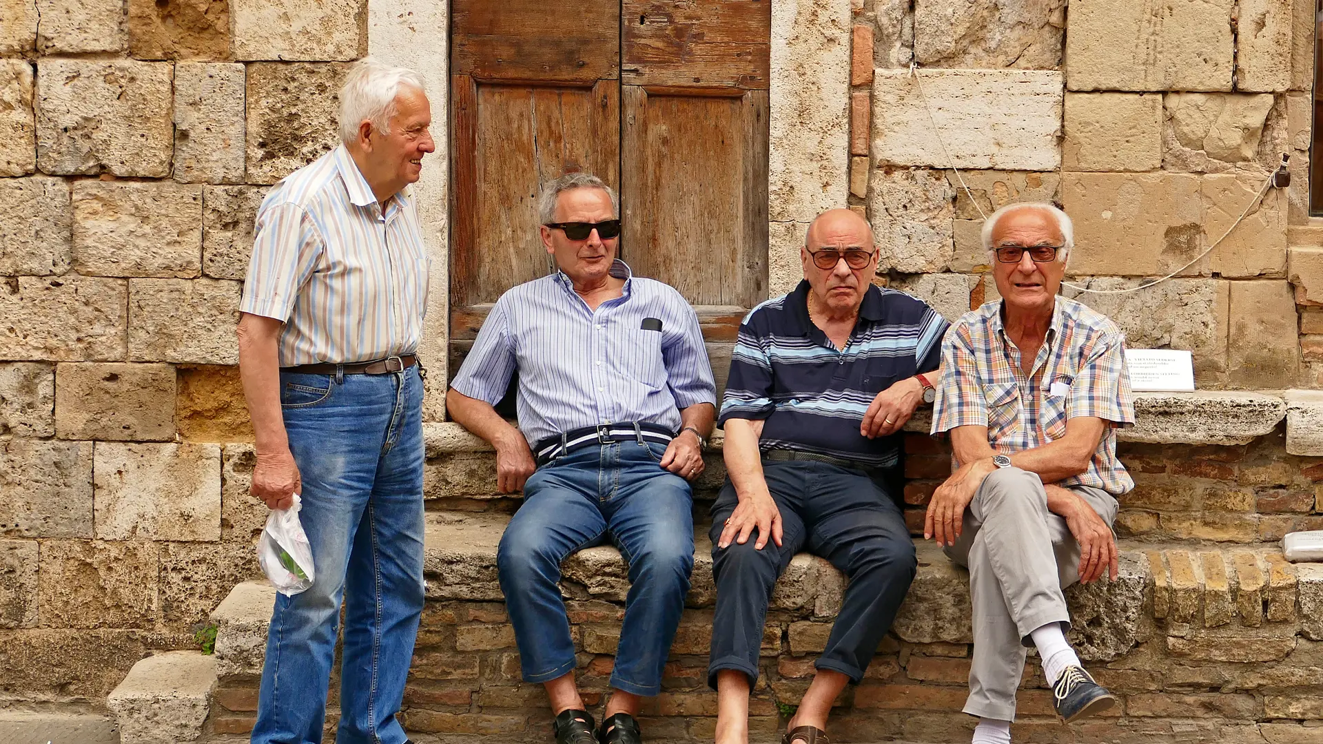 Gamle venner får en sludder på en torveplads i San Gimignano
