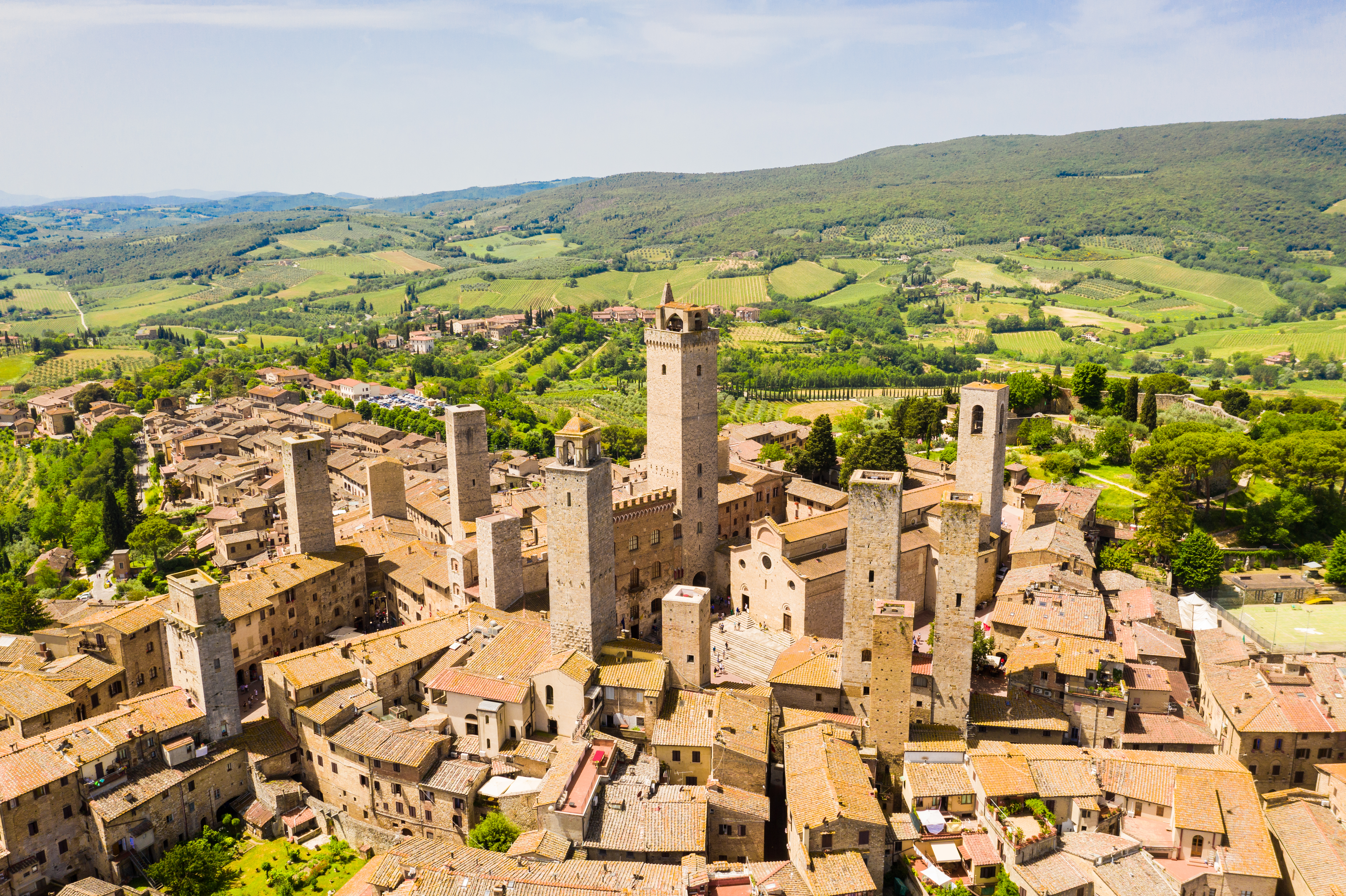 Den gamle middelalderby San Gimignano omgivet af Toscanas bølgende grønne landskab