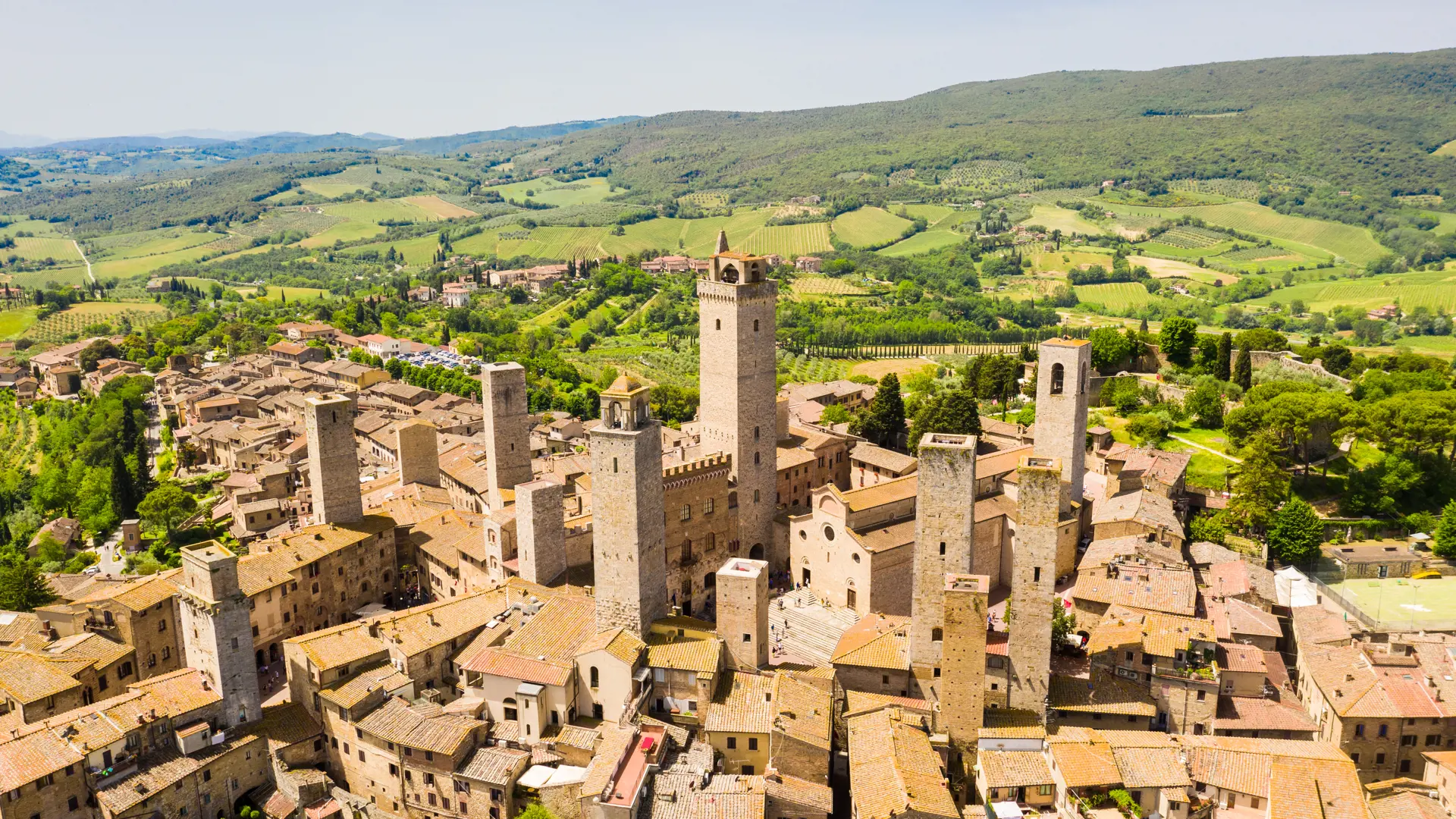 Den gamle middelalderby San Gimignano omgivet af Toscanas bølgende grønne landskab
