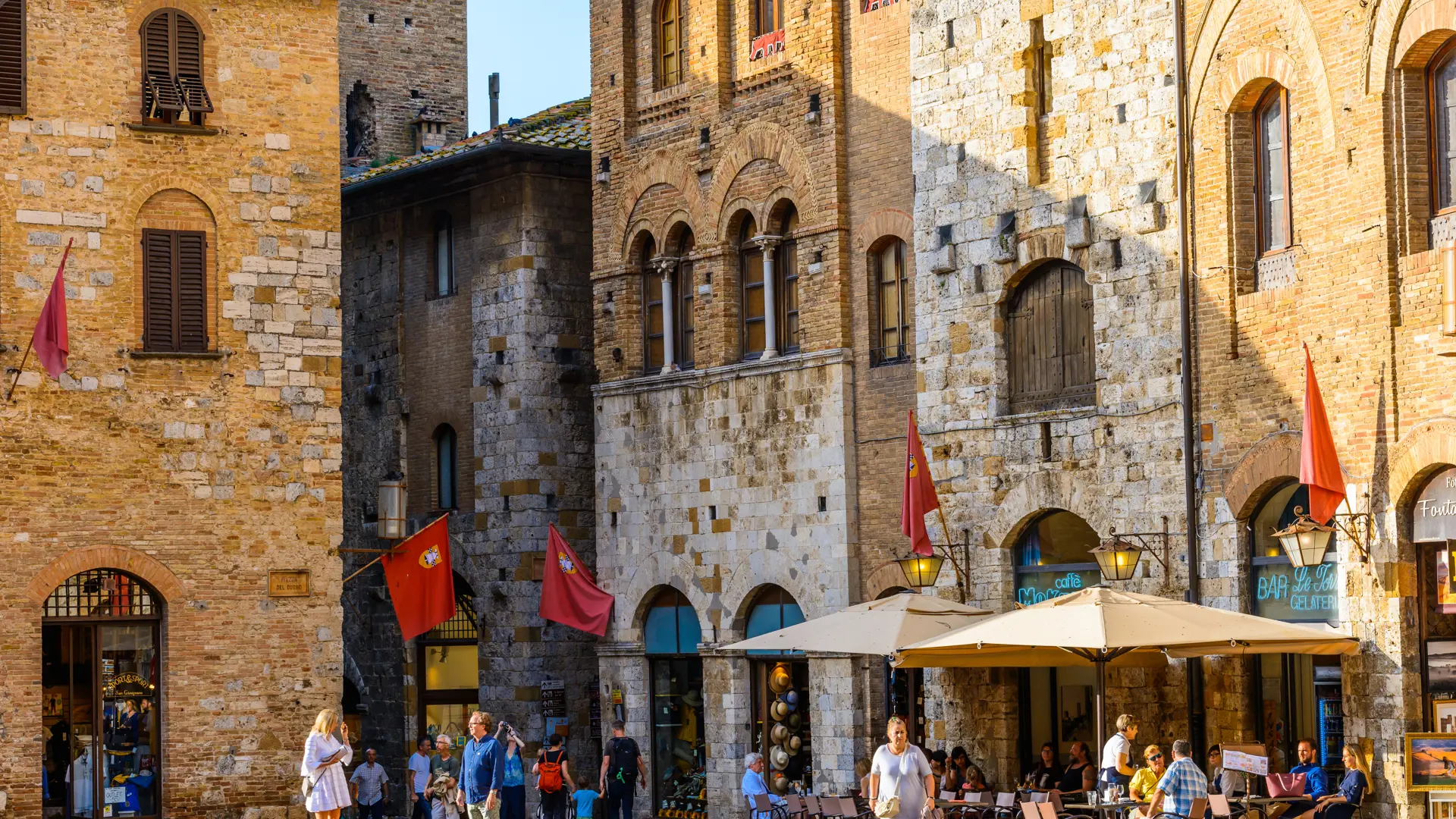 Hyggeligt gadeliv ved Piazza del Duomo i San Gimignano
