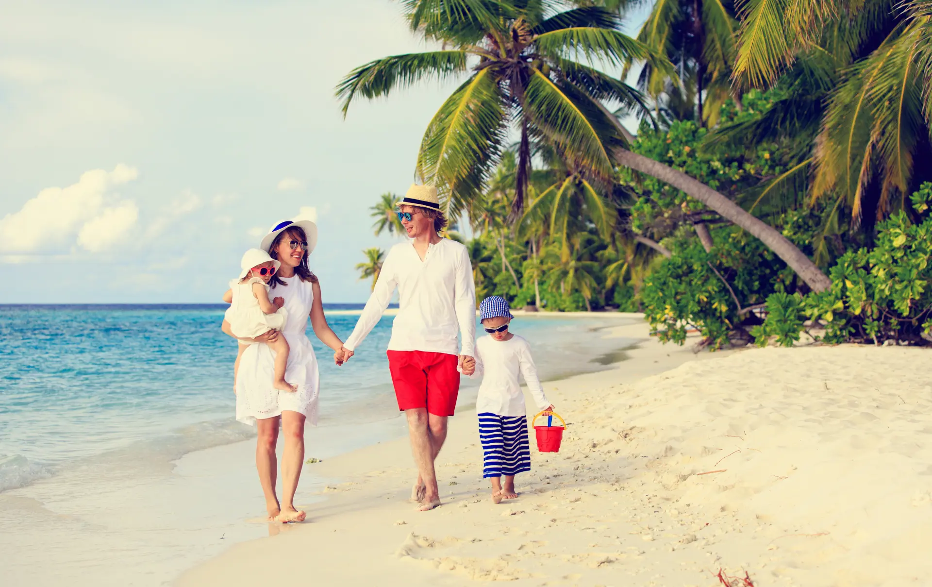 shutterstock_354414668 Young family with two kids walking at tropical beach, family beach vacation.jpg