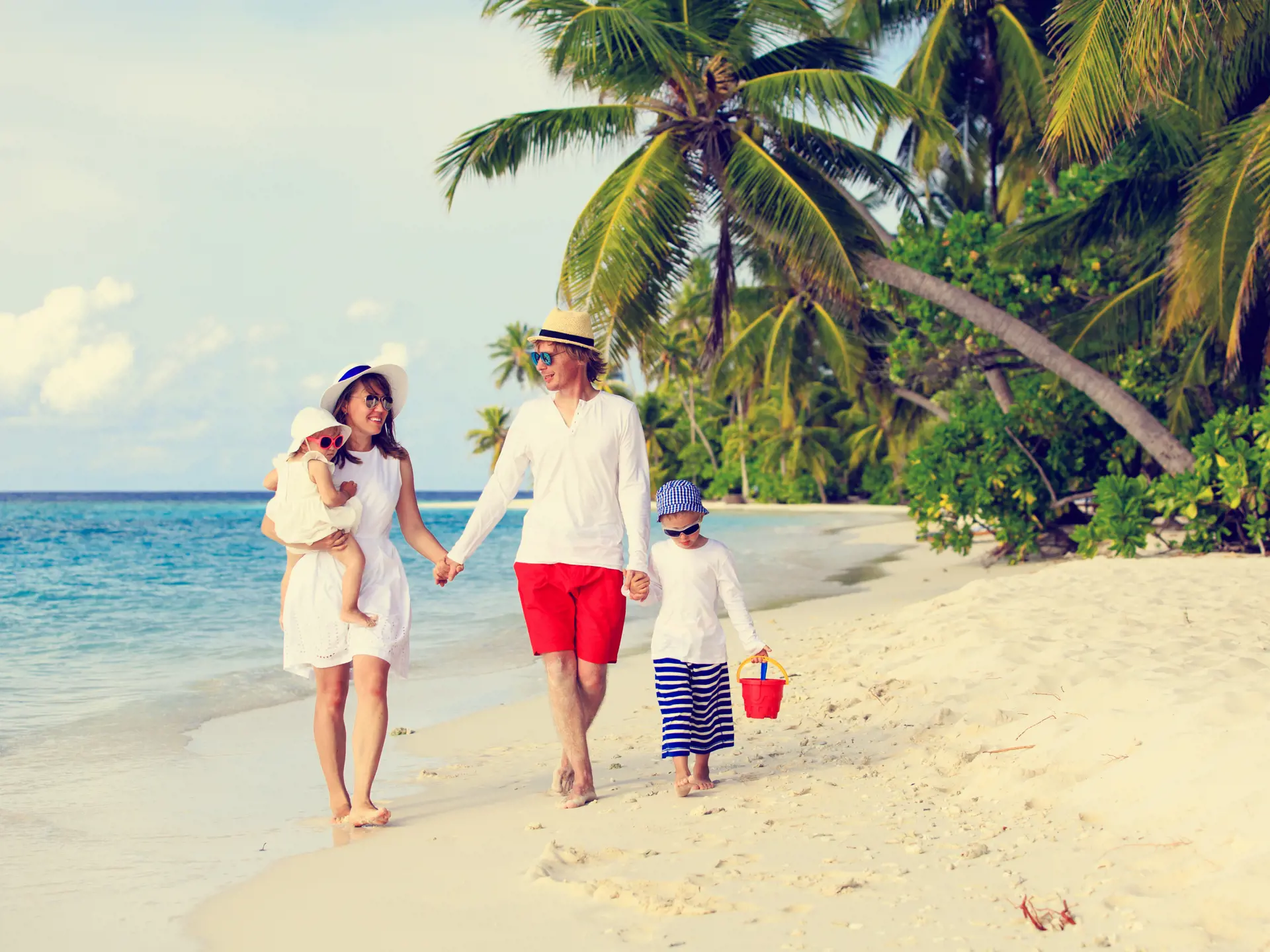 shutterstock_354414668 Young family with two kids walking at tropical beach, family beach vacation.jpg