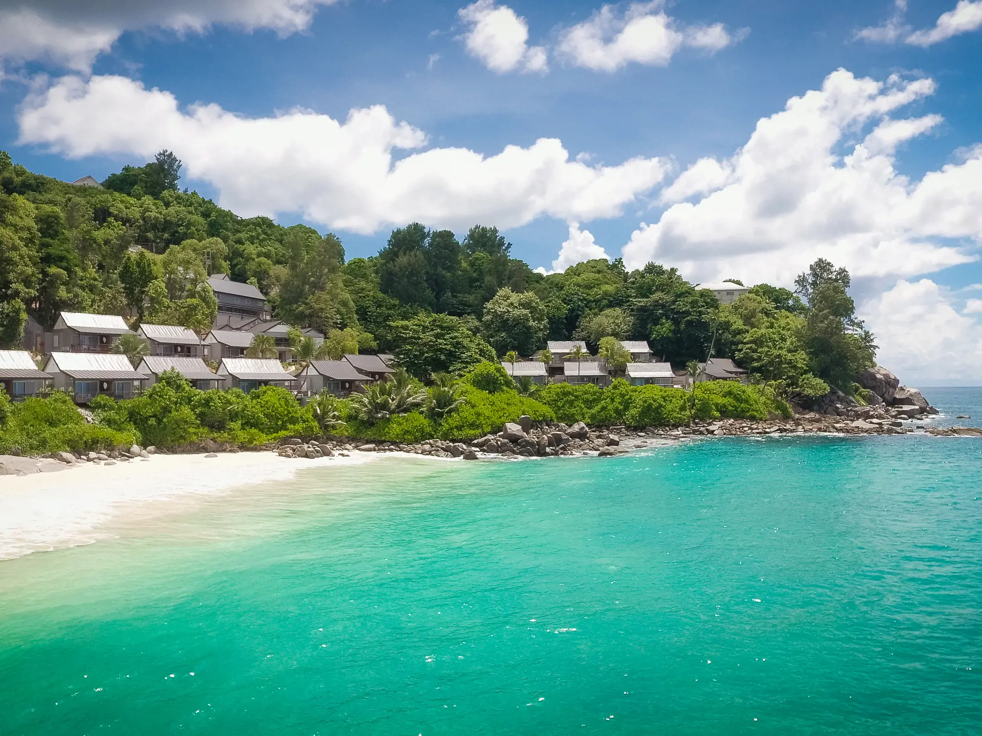 HOTELLET - De flotte hytter er placeret i grønne omgivelser med udsigt over den private strand og det smukke hav.