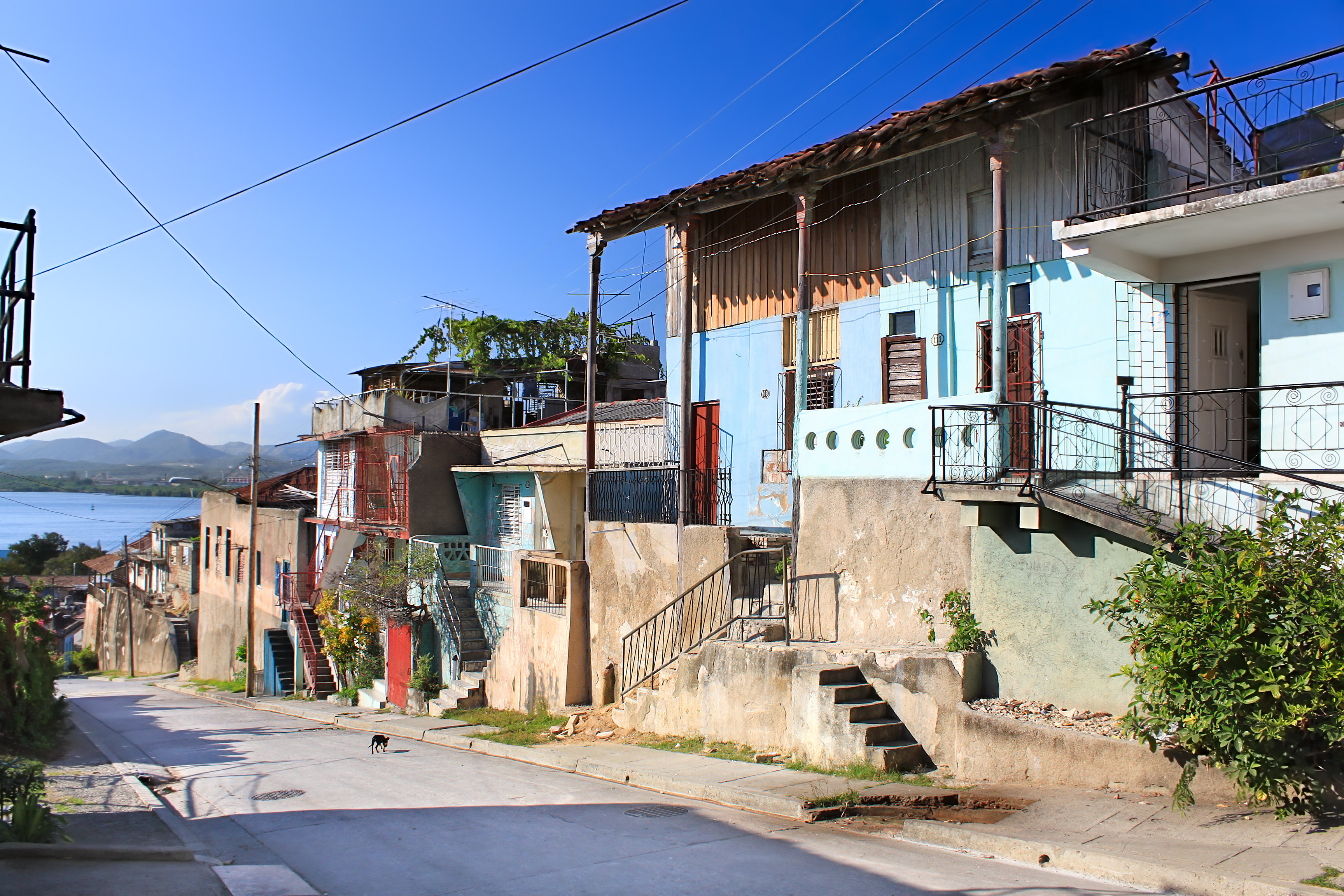 shutterstock_49509832 Panoramic view of street with crumbling buildings and view on a bay in Santiago de Cuba , Cuba.jpg