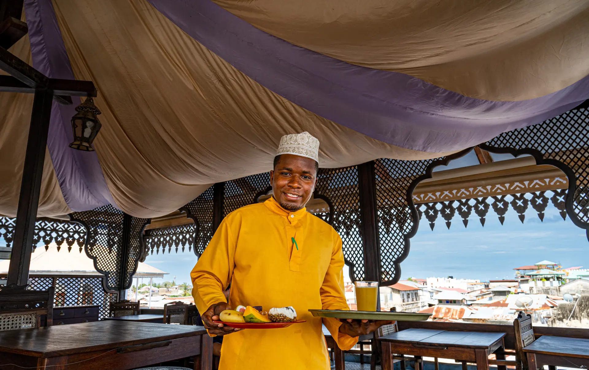 Shutterstock 2223567971 Stone Town, Zanzibar Tanzania March28,2021 Waiter Serving Breakfast On Rooftop Building In Stone Town Zanzibar