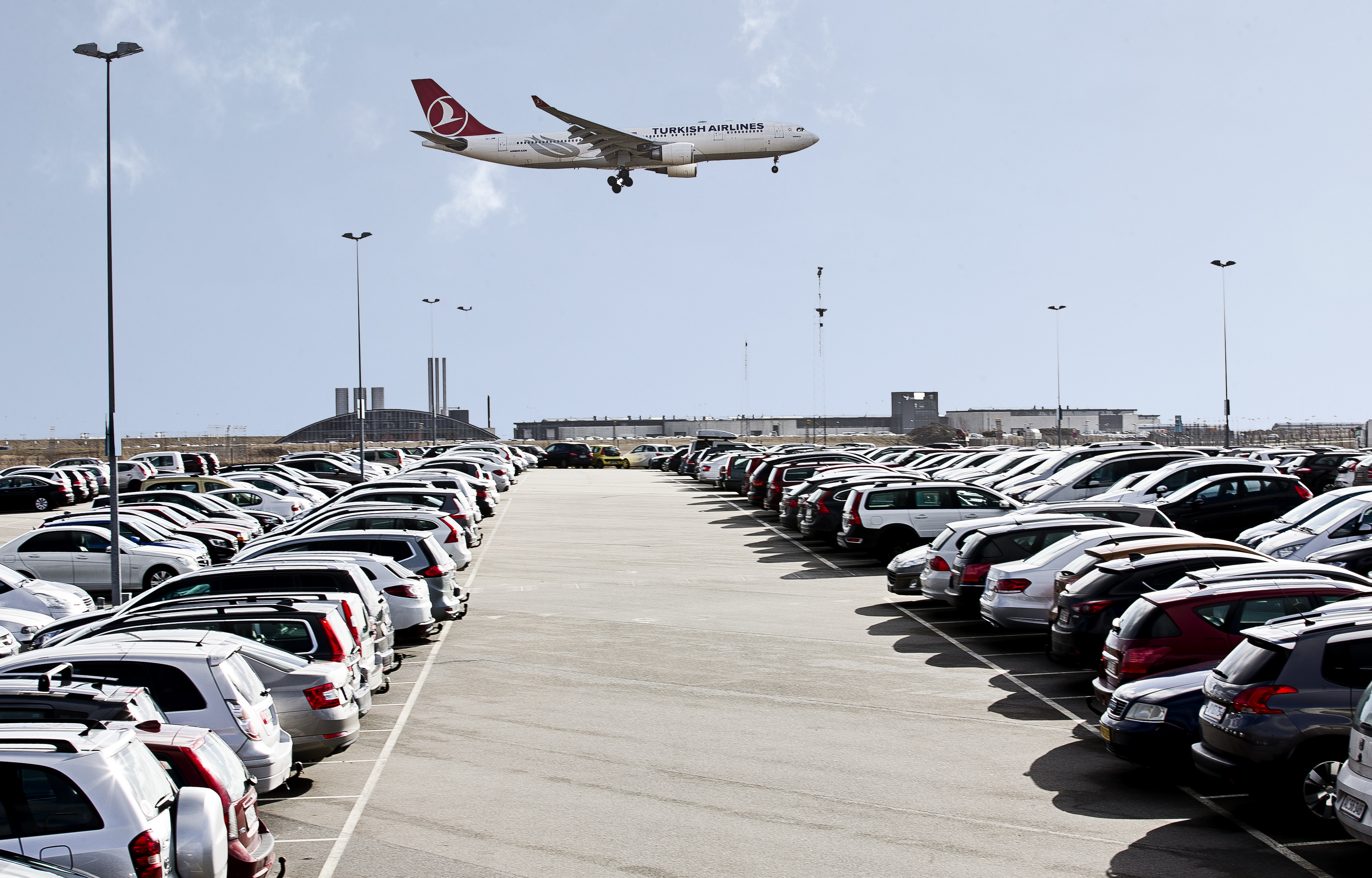 Parkeringsplads ved Københavns Lufthavn med fly i baggrunden