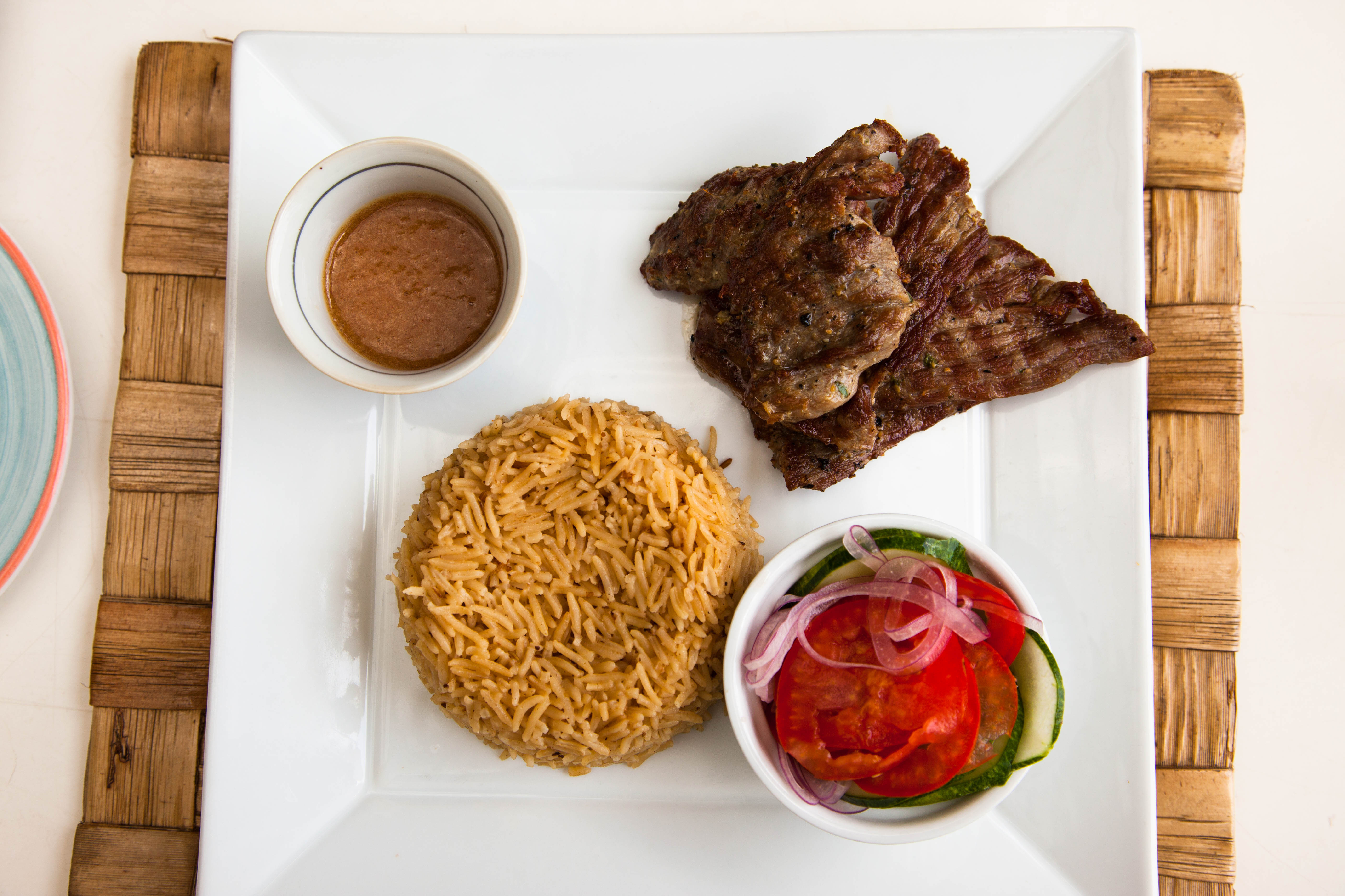 Shutterstock 560252326 Traditional Zanzibar Food, Pilau Masala With Beef. Square White Plate With The Food, The View From The Top.