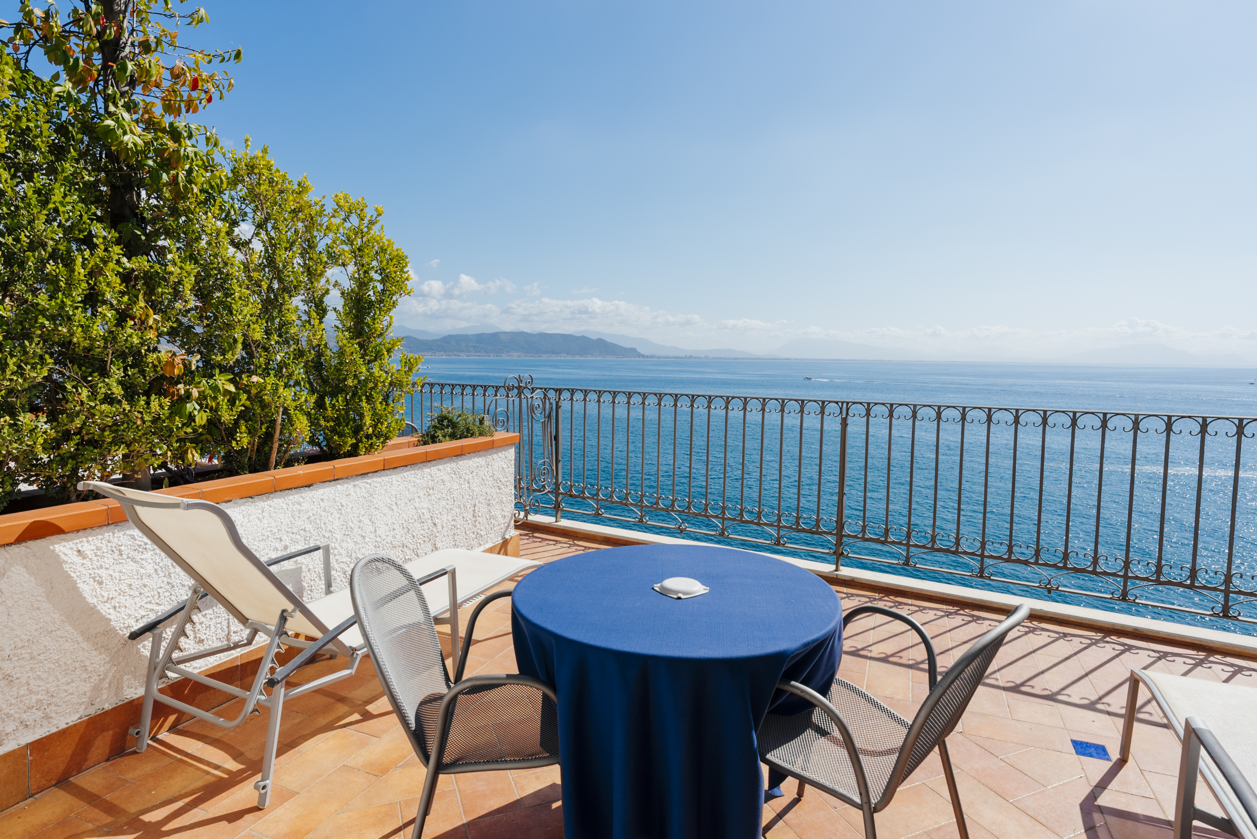 Deluxe Room har terrasse med bord, stole og liggestole